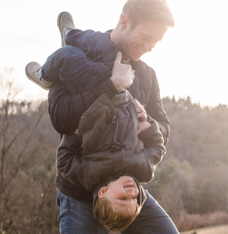 Smiling young man holding his son